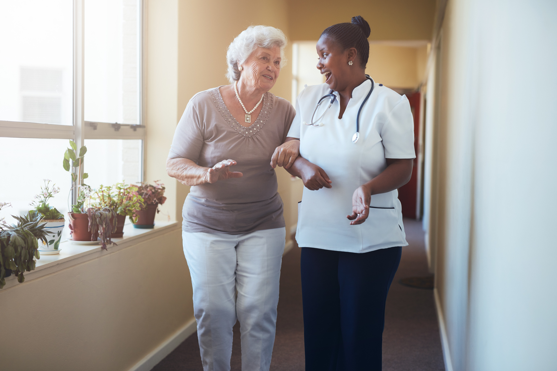 Home care aide assisting elderly woman with mobility at home in Northern Virginia